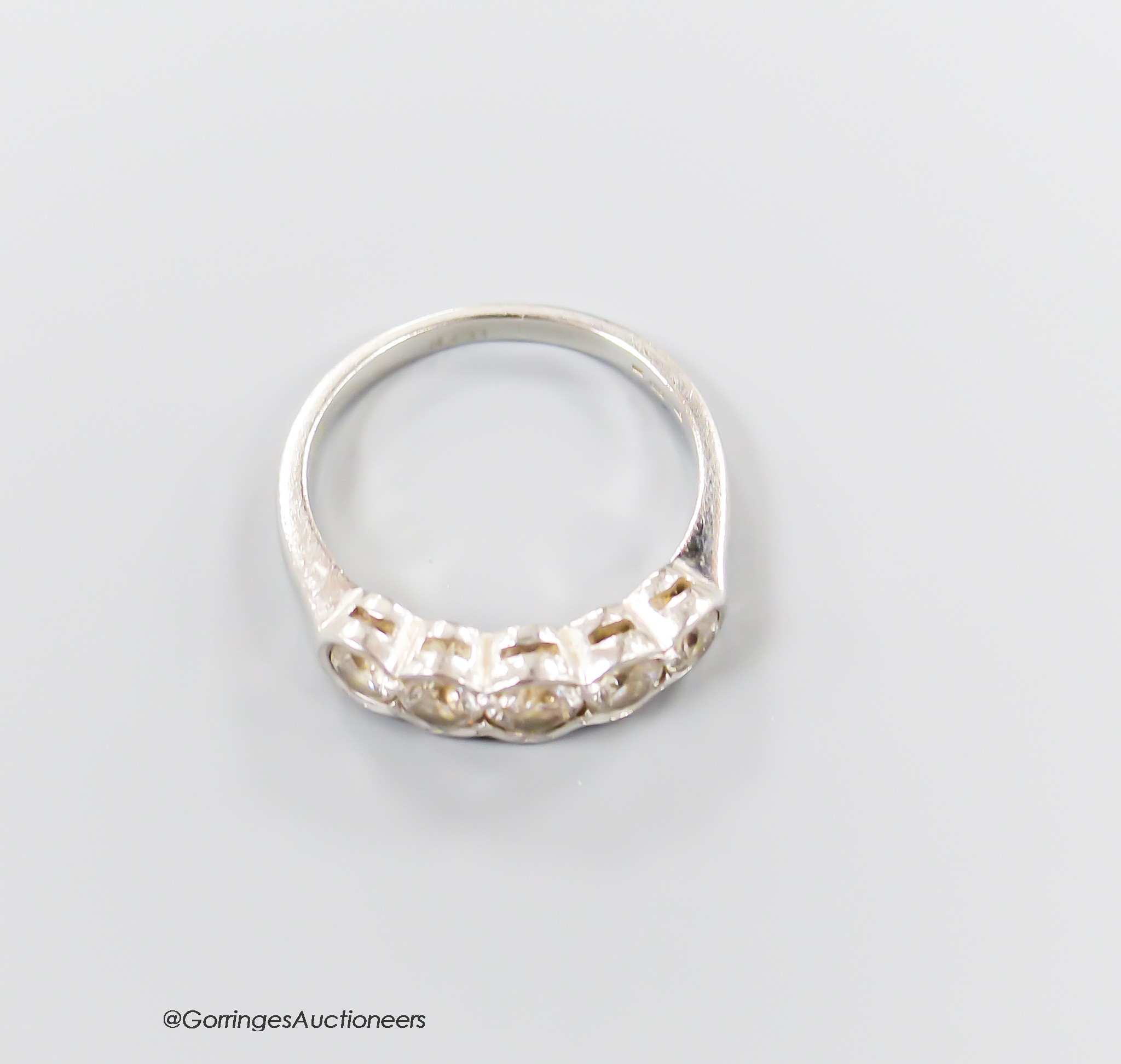 A modern platinum and graduated five-stone diamond half hoop ring, size L/M, gross 5.2 grams.